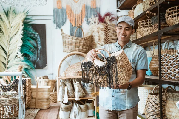 Man met de hoed houdt en kijkt naar de geweven tas — Stockfoto