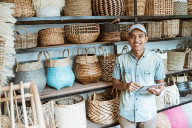 Gülümseyen Asyalı adam ayakta dururken kameraya bakıyor.