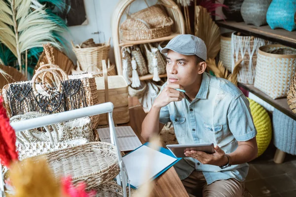 Jonge ondernemers denken serieus tijdens het gebruik van een pad tegen een handgemaakte achtergrond — Stockfoto