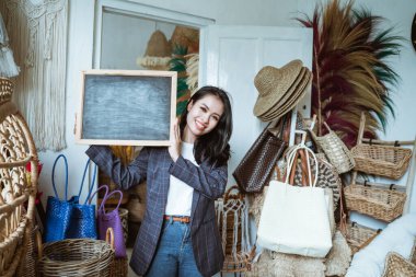 Genç girişimci, el işi geçmişi olan bir karatahta tutuyor.