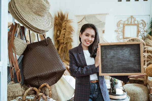 Üzletasszony blézerben egy táblát tart egy kézműves boltban. — Stock Fotó