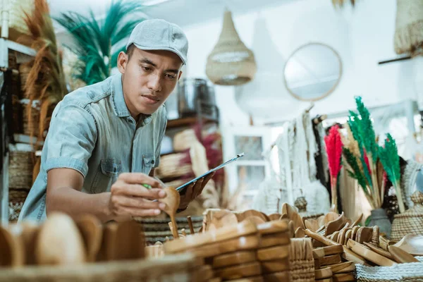 Férfi birtokol egy kézműves tárgy és vágólap, miközben ellenőrzi tételek között kézműves tárgyak — Stock Fotó