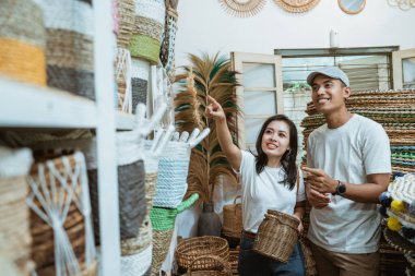 Bir çift el sanatları seçiyor ve el sanatları öğeleri arasında parmaklarını gösteriyorlar.