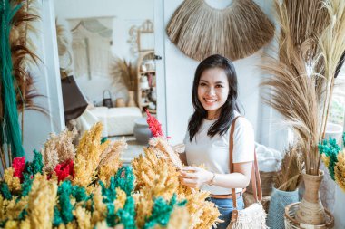 Kadınlar el sanatları galerisinde gelişigüzel yapay bitkiler bulundururlar.