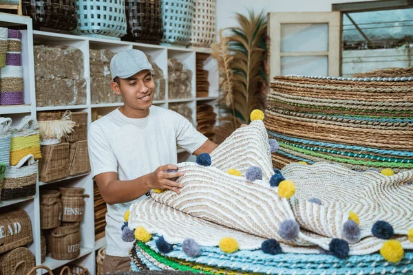 Uomo in possesso di tappeto in maglia mestiere nella galleria mestiere — Foto Stock