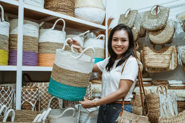 Mujer sonríe a la cámara mientras levanta una cesta tejida —  Fotos de Stock
