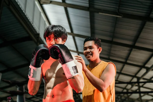 Treinador com um homem boxeador de pé juntos durante uma pausa de luta — Fotografia de Stock