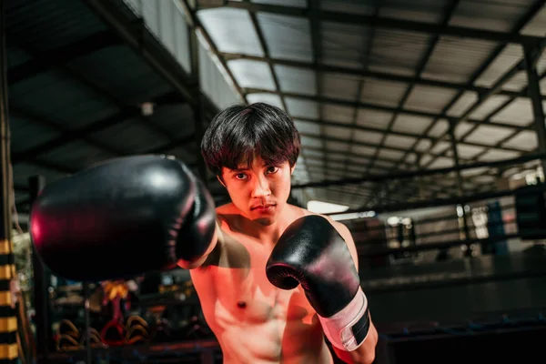 Forte e muscoloso giovane uomo in marcia da boxe fare un movimento di colpire con il copyspace — Foto Stock