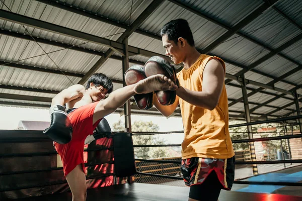 Jovem asiático homem fazendo kickboxing formação com ela treinador — Fotografia de Stock