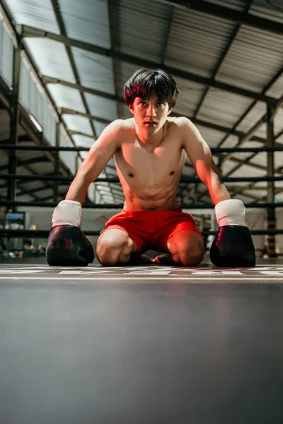 Boxeador em luvas de boxe derrotado boxeador se senta no chão — Fotografia de Stock