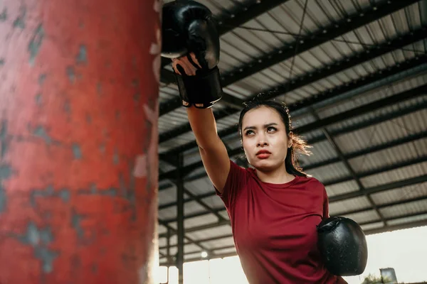 Asyalı kadın boksör sınavı kum torbasına vuruyor. — Stok fotoğraf