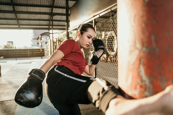 Kadın boksör kum torbasıyla tekme çalışıyor. — Stok fotoğraf