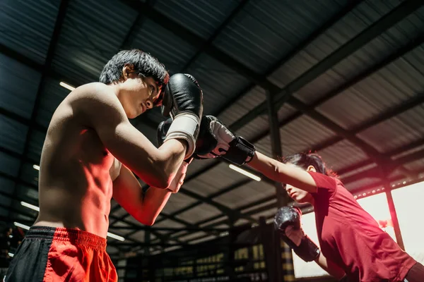 Kvinnlig fighter attackerar med slag rörelse medan tävlar mot manliga boxare — Stockfoto