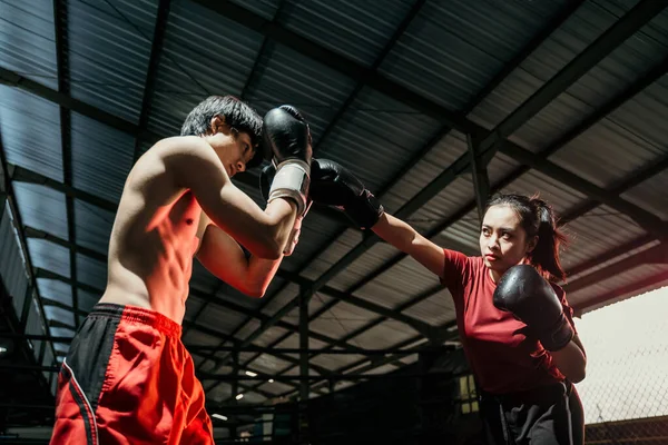 Erkek boksöre karşı mücadele ederken, yumruk hareketli kadın boksör — Stok fotoğraf