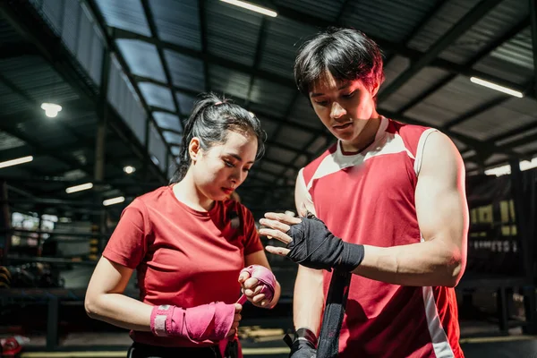 Retrato de pareja luchador aplicando la servidumbre cinta en manos — Foto de Stock
