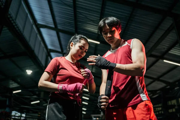 Vystřižený záběr roztržené asijské mužské a ženské bojovnice balící její ruce — Stock fotografie