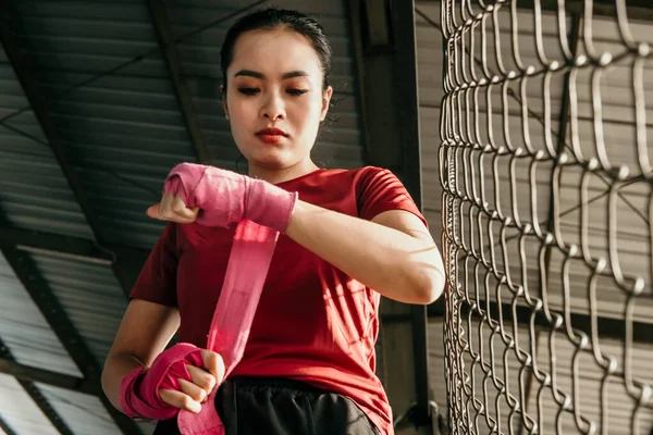 Beskuren skott av en rippad asiatisk kvinna fighter inslagning hennes händer — Stockfoto