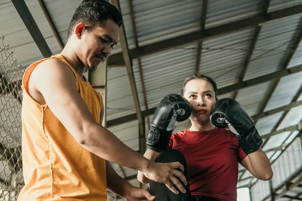 Mujer usando guantes de boxeo con su entrenador — Foto de Stock