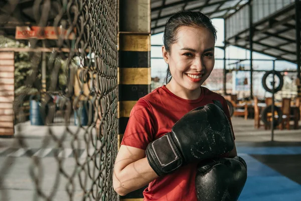 Sorrindo mulher lutador final em luvas de boxe de pé — Fotografia de Stock