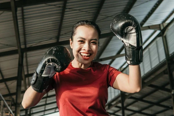 Mujer joven fuerte en equipo de boxeo hacer un movimiento de golpear — Foto de Stock