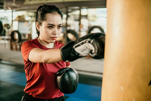 Giovane donna pugile facendo esercizio colpire sacco da boxe — Foto Stock