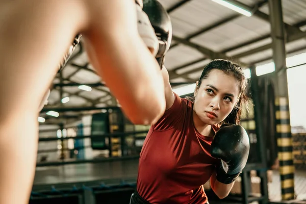 Genç kadın boksör rakibiyle rekabet ederek yumruk atıyor. — Stok fotoğraf