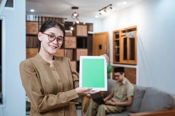 Lehrerin in Beamtenuniform mit Brille lächelt, während sie ein digitales Tablet zeigt — Stockfoto