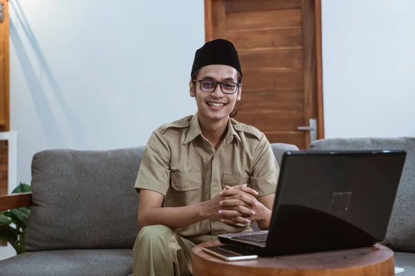 Devlet memuru üniformalı bir adam evde çalışırken dizüstü bilgisayar kullanıyor. — Stok fotoğraf