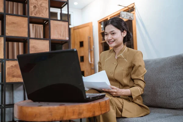 Γυναίκα με κυβερνητική στολή που κρατά έγγραφα ενώ εργάζεται από το σπίτι online — Φωτογραφία Αρχείου