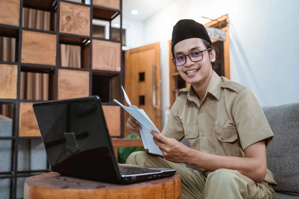 Muž učitel ve státní úředník úsměv při pohledu do kamery při práci z domova pomocí notebooku — Stock fotografie