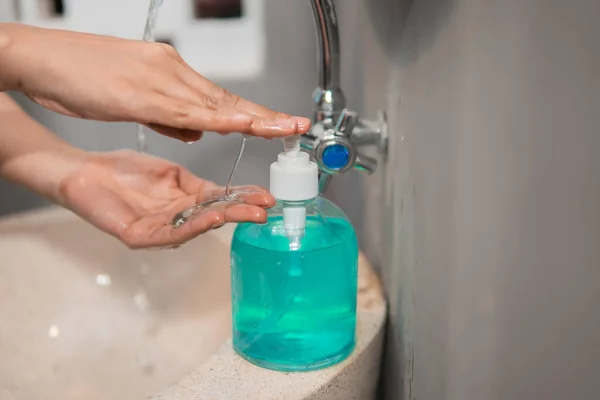 Рука сжала мыльную бутылку перед мытьем рук — стоковое фото
