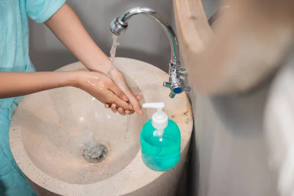 Las manos de las niñas enjuagan la espuma de jabón líquido al lavarse las manos — Foto de Stock