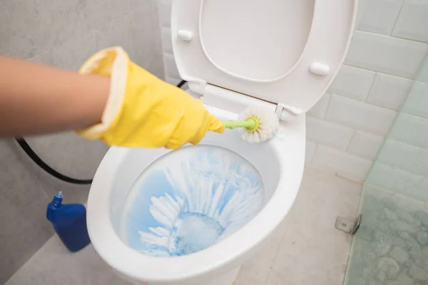 Close up of hands wearing gloves using a brush when cleaning the toilet — Stock Photo, Image