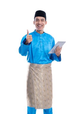 Baju koko tableti taşıyan Müslüman erkek.