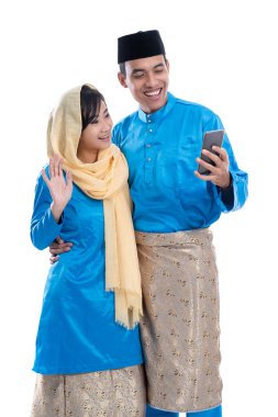 Cep telefonu kullanan Müslüman çift.