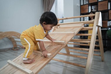 Küçük Asyalı Bebek Pikler Üçgeni Oyuncaklarına Sürüşü