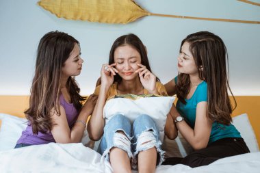 Kadınlar yatak odasında konuşuyorlar ve arkadaşlarını teselli ediyorlar.