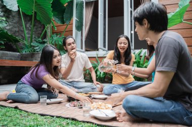 Arkadaşlar arka bahçede yiyip içerken eğleniyorlar.