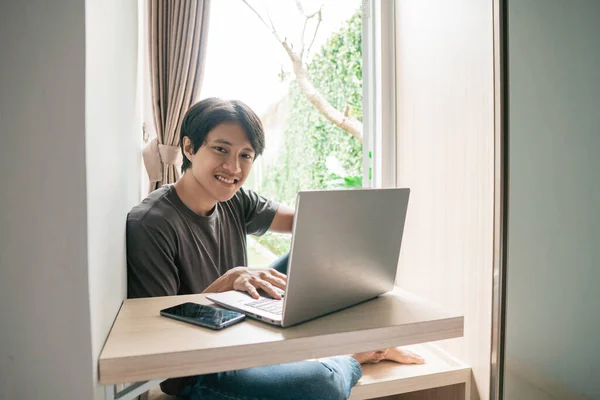 asian man designer working home using laptop at home