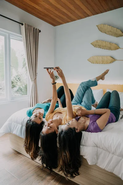 Nő fényképez barátai használ telefon, miközben együtt lógunk — Stock Fotó