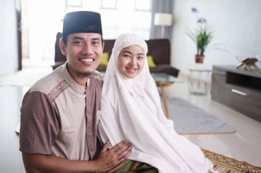 Evde birlikte dua ettikten sonra Asyalı Müslüman çift.
