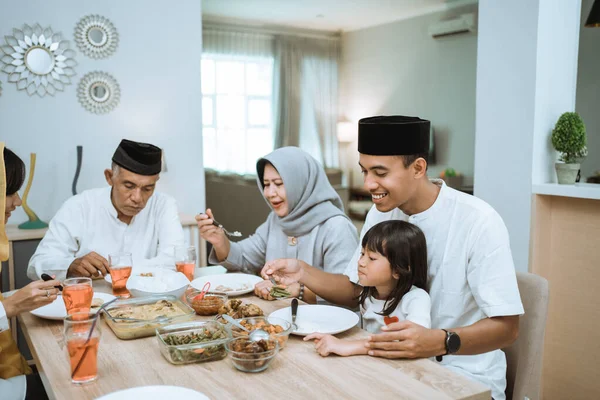 beautiful asian family enjoying their iftar dinner at home