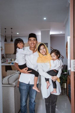 Müslüman aile, evlerinin önünde duruyor. Misafirlerini karşılıyorlar.