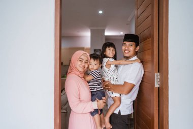 Müslüman aile, evlerinin önünde duruyor. Misafirlerini karşılıyorlar.