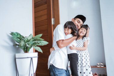 Heyecanlı baba bayram kutlamalarında çocuklarına sarılıp kucaklıyor.