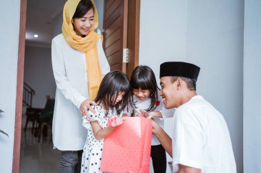 Mübarek bayramda Müslüman baba çocuklarına hediye veriyor.