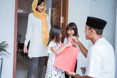 Mübarek bayramda Müslüman baba çocuklarına hediye veriyor.