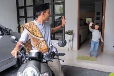 Baba, camiye gitmeden önce kızına el sallıyor.