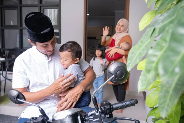 asian husband saying goodbye to his family kid and wife before leaving out by motorcycle