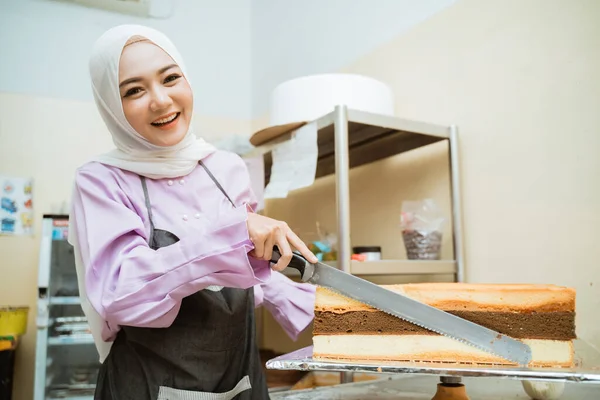 beautiful young baker making cake at her kitchen